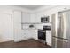 Modern kitchen with stainless steel appliances, white cabinets, granite countertop and dark hardwood floors at 996 Palmetto Sw Ave, Atlanta, GA 30314