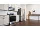Modern kitchen with stainless steel appliances, white cabinets, granite countertop and dark hardwood floors at 996 Palmetto Sw Ave, Atlanta, GA 30314