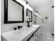 Modern bathroom featuring a double vanity, black accents, and glass-enclosed shower with elegant marble tiling at 2277 Cloverdale Se Dr, Atlanta, GA 30316