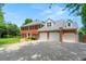 Two-story red brick home with a three car garage and driveway on a sunny day at 2903 Ashebrooke Ne Dr, Marietta, GA 30068