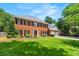 Charming two-story red brick home with manicured lawn and black shutters on a sunny day at 2903 Ashebrooke Ne Dr, Marietta, GA 30068