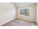 Well-lit bedroom with neutral walls, plush carpet, and a window with exterior views at 7946 White Oak Loop, Stonecrest, GA 30038