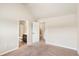 Comfortable bedroom boasts neutral walls, carpeting, and doorways leading to bathroom and closets at 7946 White Oak Loop, Stonecrest, GA 30038
