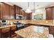 Spacious kitchen featuring stainless steel appliances, dark wood cabinets, granite countertops, and pendant lighting at 7946 White Oak Loop, Stonecrest, GA 30038