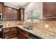 Well-lit kitchen with granite countertops, stainless steel appliances, and dark cabinetry, offering ample workspace at 7946 White Oak Loop, Stonecrest, GA 30038