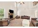 Cozy living room boasts soaring ceilings, a stone fireplace, and comfortable seating for relaxation at 7946 White Oak Loop, Stonecrest, GA 30038
