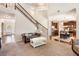 Spacious living room with staircase, flowing into kitchen, hardwood floors, and carpeted seating area at 7946 White Oak Loop, Stonecrest, GA 30038