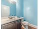 A powder room with a pedestal sink, single vanity, toilet, and hardwood floors at 1022 Nestling Dr, Lawrenceville, GA 30045