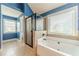Bright bathroom featuring a soaking tub, tile floor, and walk-in shower with glass enclosure at 1022 Nestling Dr, Lawrenceville, GA 30045