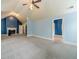 Open bonus room with a fireplace on a navy accent wall, neutral carpet, and ceiling fan at 1022 Nestling Dr, Lawrenceville, GA 30045