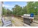 A wooden deck, including an outdoor grill and seating, overlooking a wooded backyard at 1022 Nestling Dr, Lawrenceville, GA 30045