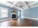 Living room with a cozy fireplace, hardwood flooring, coffered ceilings, and natural light at 1022 Nestling Dr, Lawrenceville, GA 30045