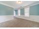 Bright living room with neutral carpet, large windows with trim, and classic wall molding at 1022 Nestling Dr, Lawrenceville, GA 30045