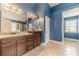 Blue tiled bathroom with dark wood cabinets, granite countertops, double sinks and mirrors at 1022 Nestling Dr, Lawrenceville, GA 30045