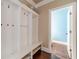 Mud room featuring built-in storage bench and coat rack near a bathroom with hardwood flooring at 1022 Nestling Dr, Lawrenceville, GA 30045