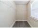 A walk-in closet with shelving, carpet flooring, base trim, and natural light from a window at 1022 Nestling Dr, Lawrenceville, GA 30045