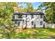 A two-story home with a wooden deck, lush greenery, and manicured lawn is pictured from the back at 2552 Hunton Ne Ct, Marietta, GA 30068