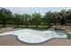 In-ground pool in need of replastering with a waterfall feature, surrounded by lush landscaping at 2609 Jacobs Crest Cv, Grayson, GA 30017