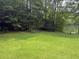 Expansive lawn gently slopes towards a tranquil lake surrounded by dense, mature trees at 4221 Riverlake Way, Snellville, GA 30039