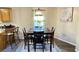 Dining area featuring a modern light fixture, wooden table set, and a window with natural light at 4221 Riverlake Way, Snellville, GA 30039
