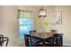 Dining area featuring a modern light fixture, wooden table set, and a window with natural light at 4221 Riverlake Way, Snellville, GA 30039