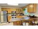 Well-lit kitchen featuring oak cabinets, stainless steel appliances, and a tile backsplash at 4221 Riverlake Way, Snellville, GA 30039