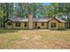 View of backyard with trees and the house, featuring a patio and a chimney at 225 Hardwood Dr, Covington, GA 30016
