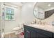 Bathroom featuring a blue vanity, granite countertop, modern fixtures, and a window at 225 Hardwood Dr, Covington, GA 30016