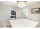 Bright dining room featuring stylish lighting, a white table, and a view into the modern kitchen at 225 Hardwood Dr, Covington, GA 30016