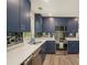 Modern kitchen featuring navy cabinets, stainless steel appliances, and a unique backsplash at 225 Hardwood Dr, Covington, GA 30016