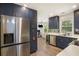 Modern kitchen with navy cabinets, stainless steel appliances, and unique backsplash at 225 Hardwood Dr, Covington, GA 30016