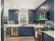 Modern kitchen with navy cabinets, stainless steel appliances, and unique backsplash at 225 Hardwood Dr, Covington, GA 30016
