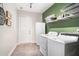 A practical laundry room offers a full-sized washer, dryer and shelving for optimal storage and organization at 232 Christian Cir, Carrollton, GA 30116