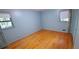 Serene bedroom with hardwood floors, two windows, and soft blue walls for a relaxing retreat at 2600 Amberly Dr, Dunwoody, GA 30360