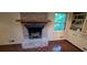 Close up of a brick fireplace with a wood mantle, and parquet flooring at 2600 Amberly Dr, Dunwoody, GA 30360