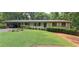 Charming single-story home featuring a well-manicured lawn, carport, and brick accents at 2600 Amberly Dr, Dunwoody, GA 30360