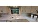 Double sink in a traditional kitchen, paired with cream-colored cabinets and tiled backsplash at 2600 Amberly Dr, Dunwoody, GA 30360