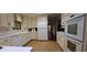 Classic kitchen featuring white appliances, cabinetry, and hardwood floors for timeless appeal at 2600 Amberly Dr, Dunwoody, GA 30360