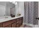 Bathroom featuring a double vanity, granite countertops and a bathtub with a patterned shower curtain at 2953 Balvenie Pl, Acworth, GA 30101