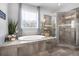 Soaking tub and tile and glass shower in a bright bathroom with a large window bringing in natural light at 2953 Balvenie Pl, Acworth, GA 30101