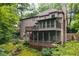 Exterior view of a home with a multi-tiered deck, screened porch, and beautifully landscaped backyard at 5049 Lake Ter, Marietta, GA 30068
