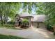 Elegant brick home with attached two-car garage and a beautifully landscaped front yard, featuring mature trees and lush greenery at 5049 Lake Ter, Marietta, GA 30068