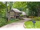 Charming brick home featuring lush landscaping, a curving driveway, and a quaint mailbox, nestled among mature trees and greenery at 5049 Lake Ter, Marietta, GA 30068