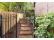 Stone pathway with wrought iron railing, framed by wood fence and lush greenery, leads to the backyard at 5049 Lake Ter, Marietta, GA 30068