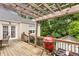 Outdoor deck with wooden pergola over an outdoor dining set with seating and a red kamado grill at 711 Greenview Ne Ave, Atlanta, GA 30305