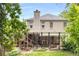 View of the backyard featuring a large deck, stone foundation, stairs, and mature landscaping at 711 Greenview Ne Ave, Atlanta, GA 30305