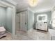 Well-lit bathroom with marble floors, white vanity with gold accents, and decorative light fixture at 711 Greenview Ne Ave, Atlanta, GA 30305