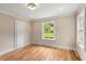 Bright bedroom featuring hardwood floors, neutral paint, and a window overlooking a green lawn at 711 Greenview Ne Ave, Atlanta, GA 30305