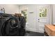 Modern laundry room equipped with gray front-loading washer and dryer next to a white paneled door at 711 Greenview Ne Ave, Atlanta, GA 30305