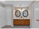 Bathroom with double sink vanity, wood cabinets, framed mirrors, and modern lighting fixtures at 812 Roget Way, Lawrenceville, GA 30045